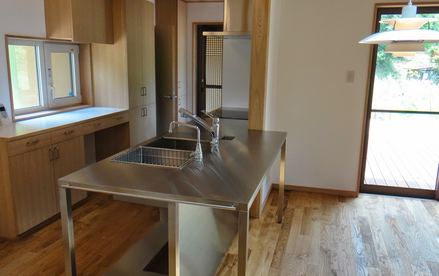 キッチンは業務厨房タイプのオープン、収納は木製キャビネットの実用重視